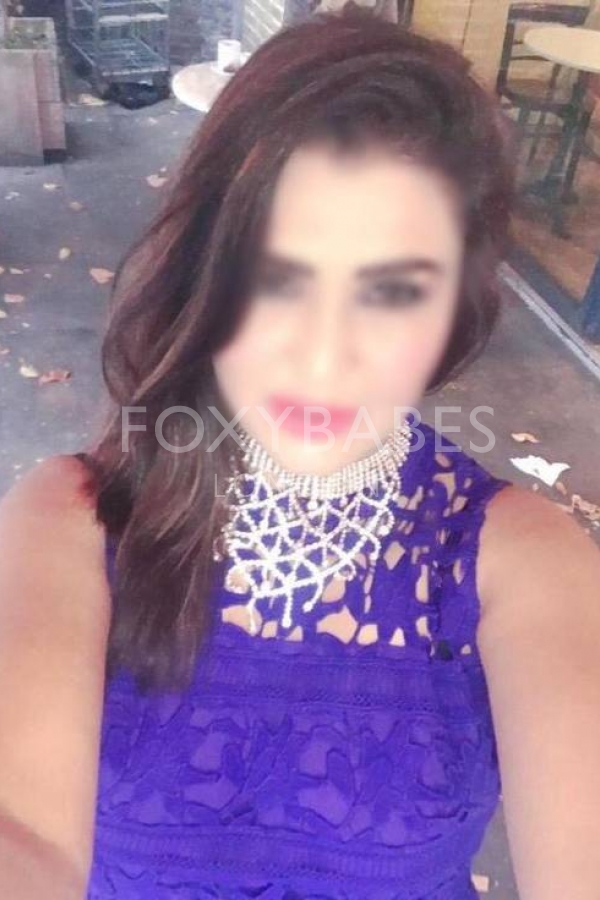 Aesha in blue dress taking selfie 
